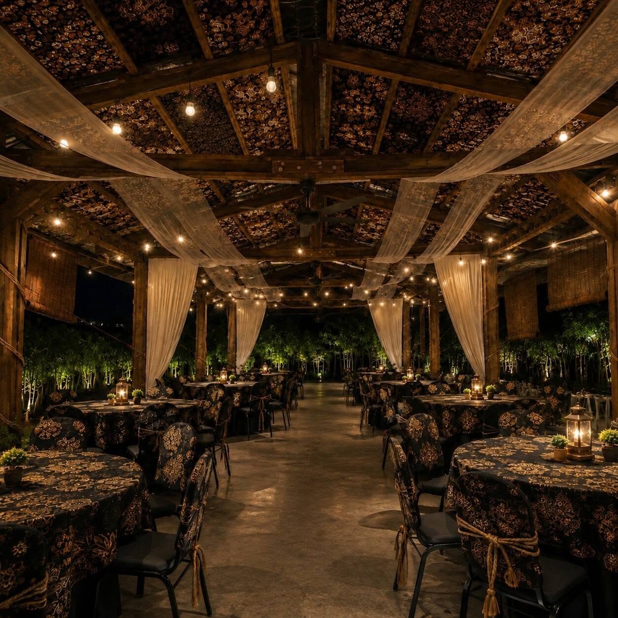 Round guest tables dressed in batik under drapes and warm lantern light at YMT The Kayu Hall