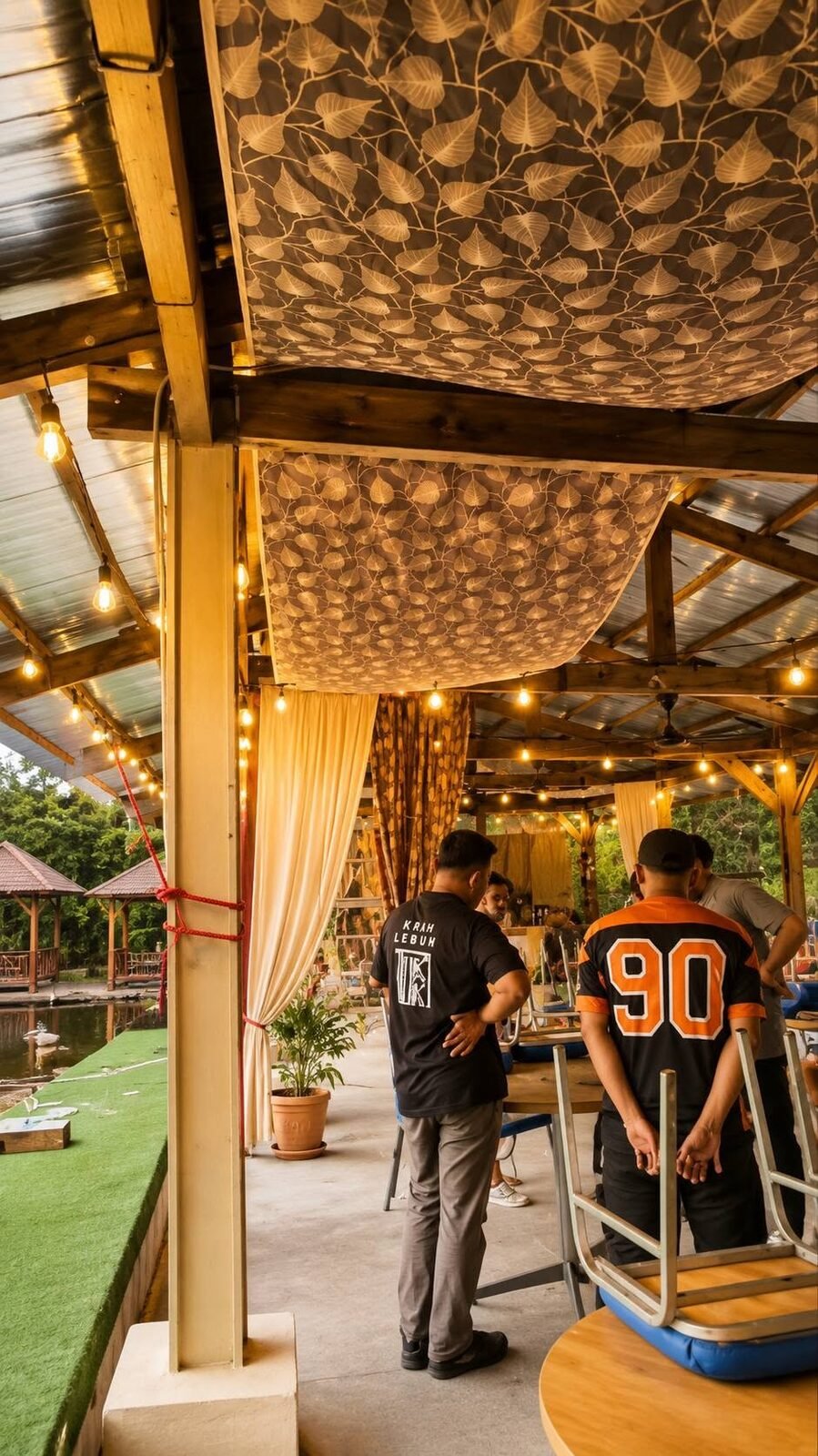 Event preparation beneath the timber roof and batik ceiling drapes of the hall